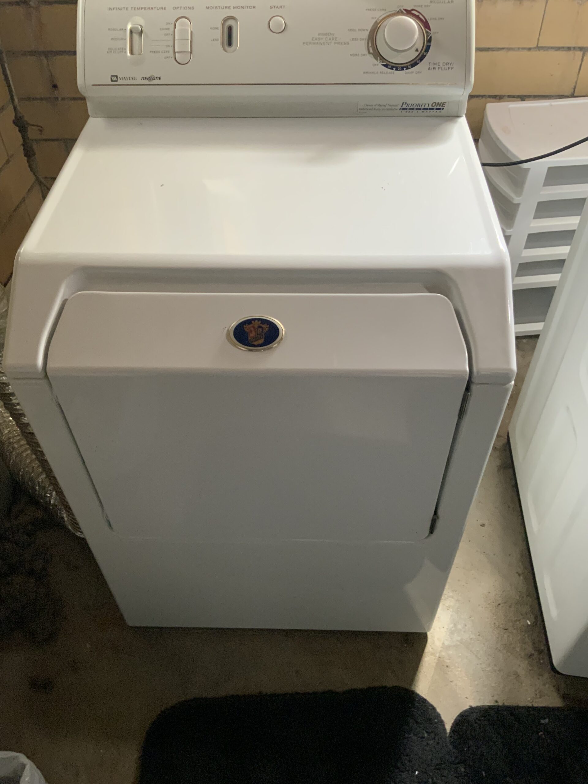 Technician Samuel Willhite replacing drum support wheel in Maytag MDG3000AWW dryer in North Canton.