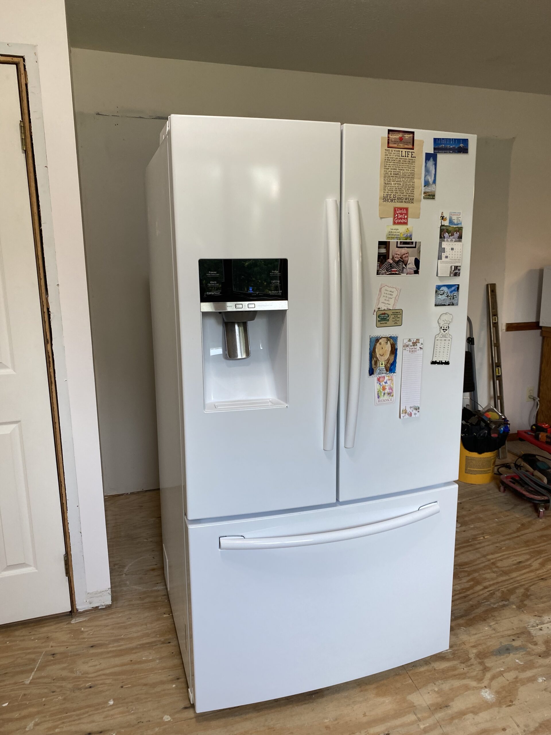 Technician repairing Samsung fridge in Alliance, Ohio with new evaporator cover and drain tube.