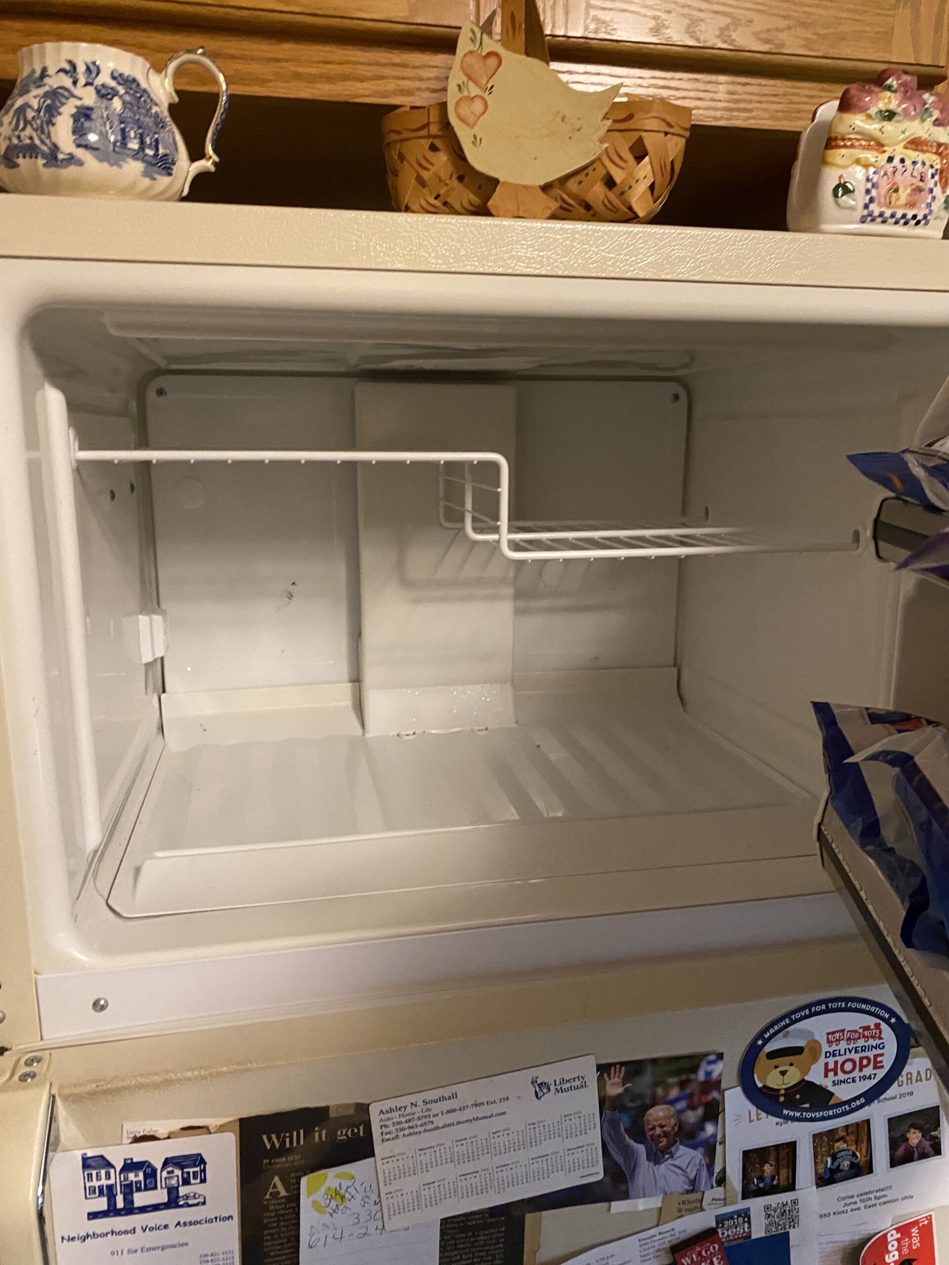 GE refrigerator with the freezer on top, undergoing repair by a technician in Alliance, OH.