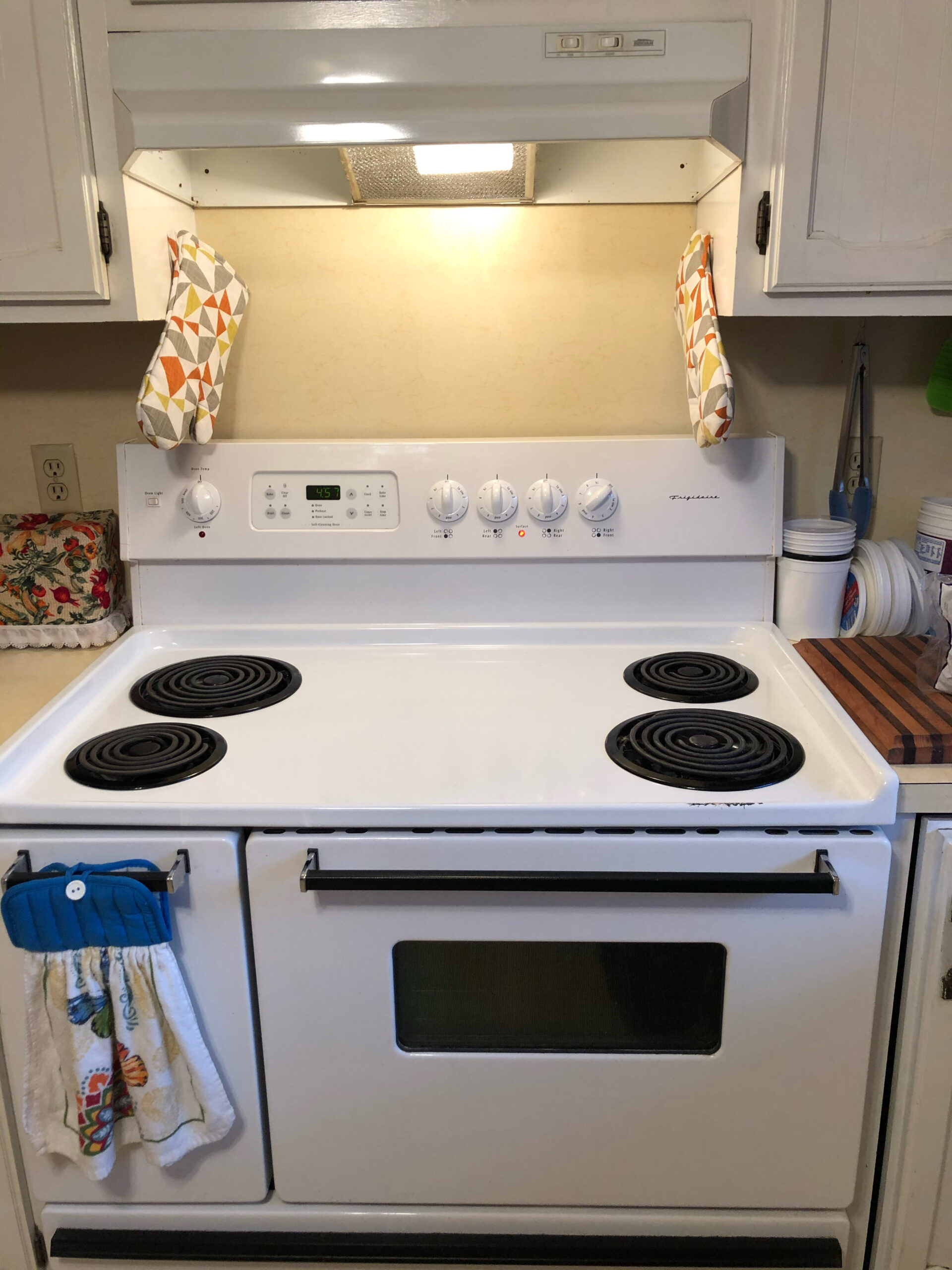 Frigidaire oven stove top with technician replacing the right front infinite switch